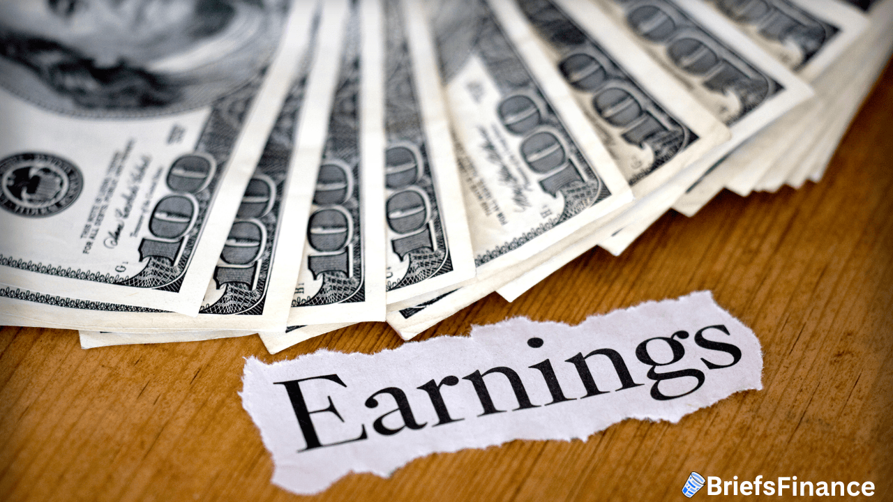 A stack of hundred-dollar bills fanned out on a wooden surface beside a torn piece of paper with the word "Earnings" printed on it.