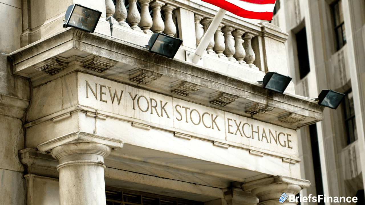 The stone facade of the New York Stock Exchange building with its name engraved and part of an American flag visible above.