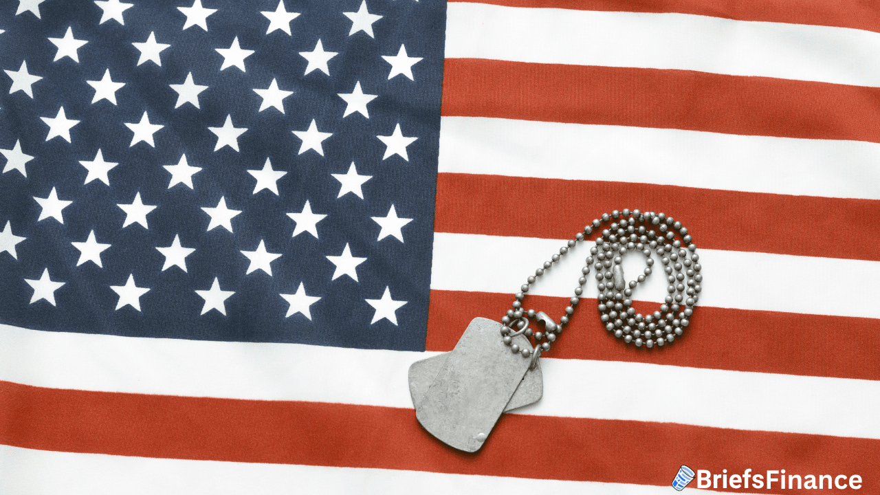 A pair of military dog tags with a ball chain placed on a United States flag.
