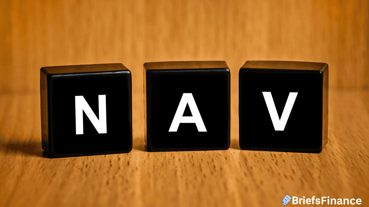 Three black cubes with the white letters "N," "A," and "V" are arranged in a row on a wooden surface, with the BriefsFinance logo in the bottom right corner.