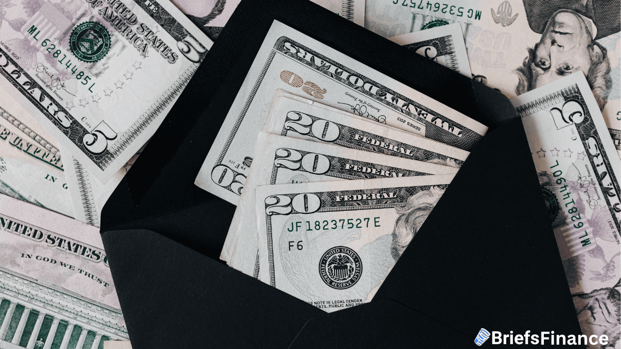 An open black envelope with various denominations of U.S. dollar bills, lying on a spread of other U.S. banknotes.