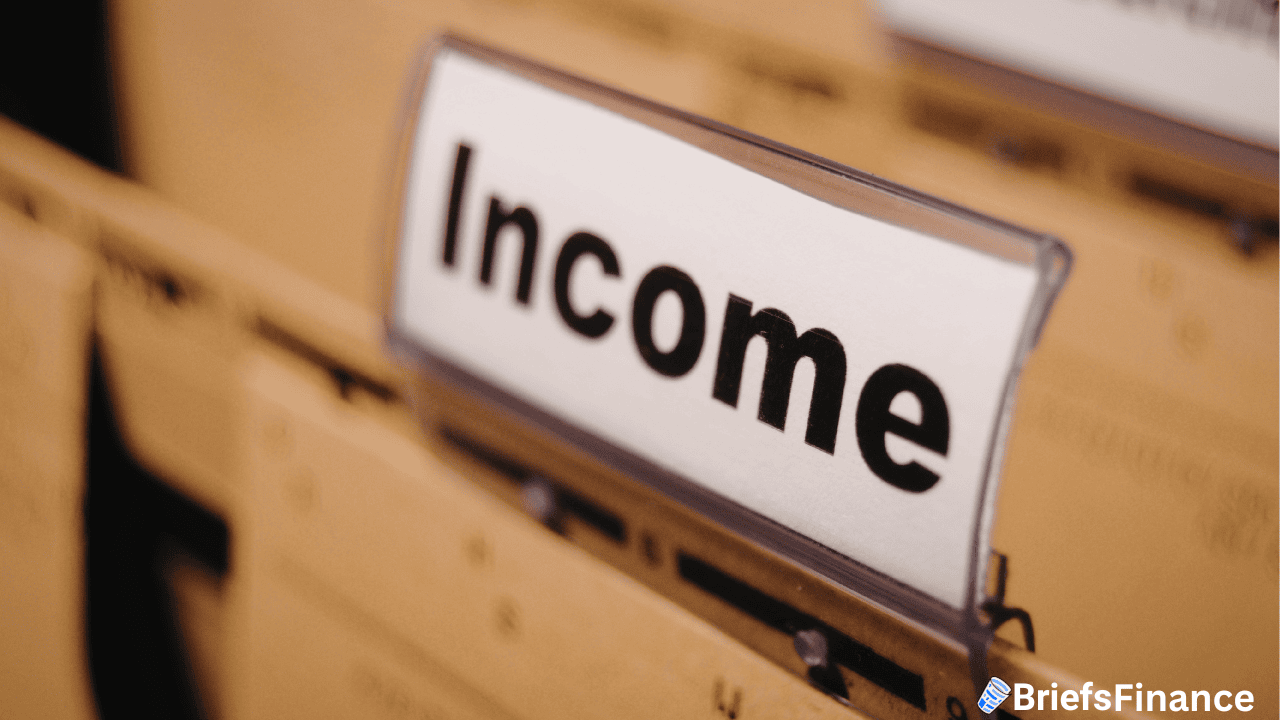 A file folder labeled "Income" is in focus among several other folders. The BriefsFinance logo appears in the bottom right corner.